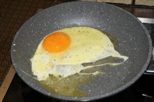 Das Ei in Butter braten.