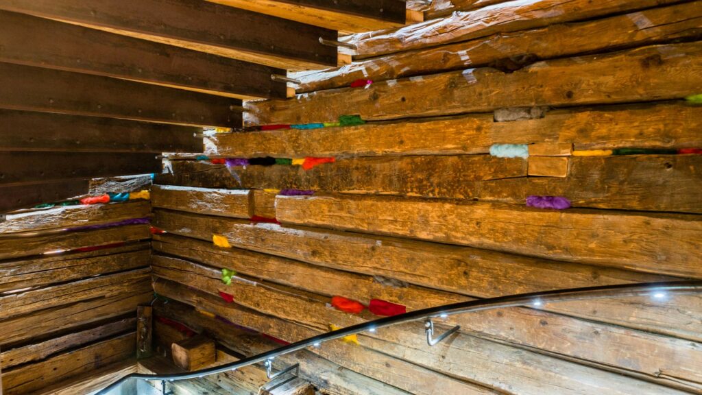 Die Schafschurwolldämmung von Villgrater Natur ist eigentlich unsichtbar, bunte Schafwolle als Deko-Element im Treppenhaus holt sie ins Rampenlicht.