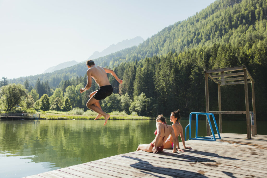 Jugendliche am See Mann springt hinein