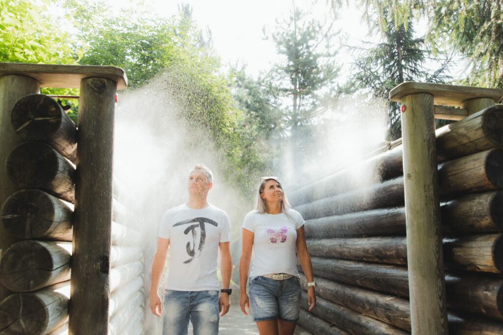 Ein Mann und eine Frau genießen den feinen Kräuter-Sprühnebel im Vitalpinum