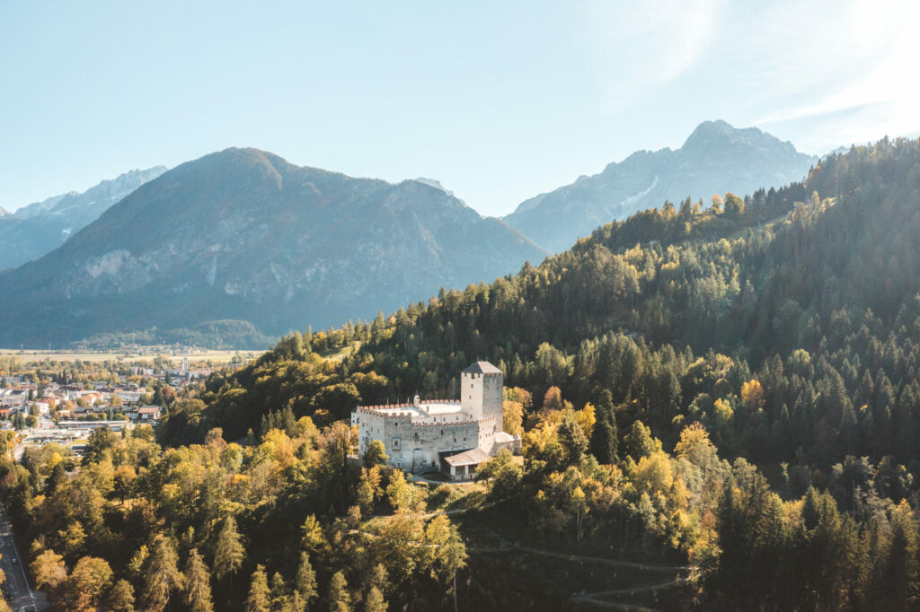 Aufnahme des Schloss Bruck bei strahlendem Sonnenschein von oben und mit Blick in Richtung Lienzer Dolomiten