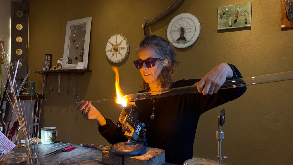 Glasbläserin Veronika Petutschnig formt mit einer Flamme ein Kunstwerk aus Glas in ihrer Werkstatt.