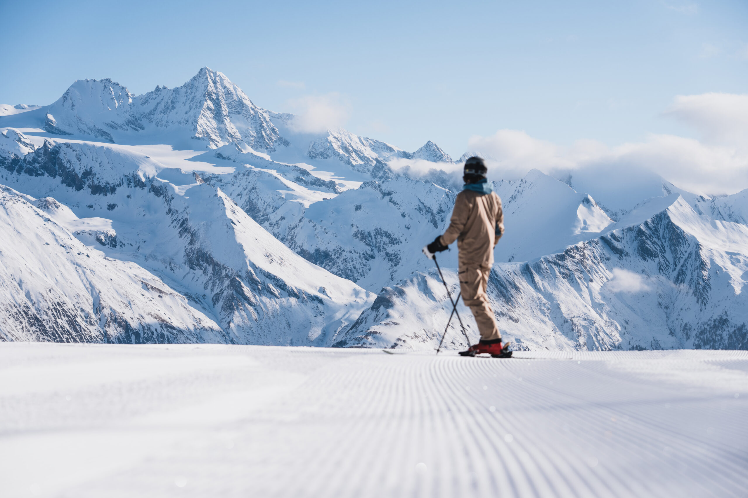 Skifahrer auf einer Piste in Osttirol mit vielen Gipfeln im Hintergrund.