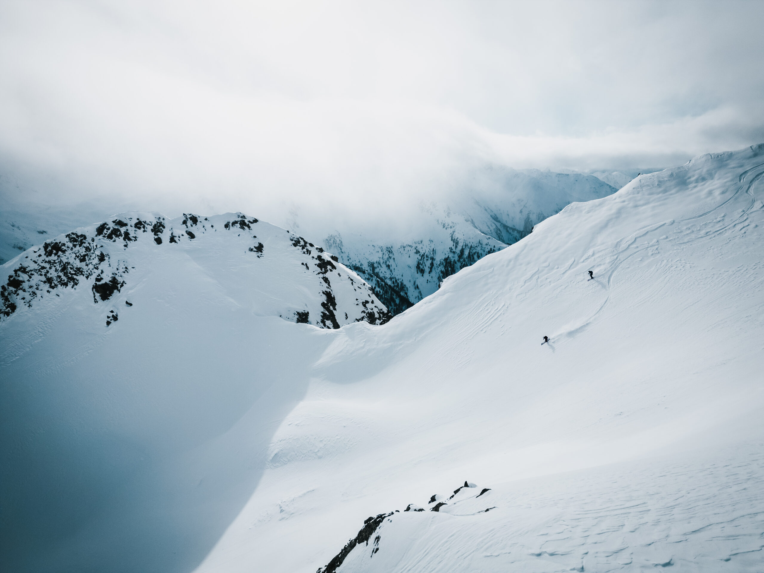 Abfahrt mit Skiern im steiler, unberührter Berglandschaft.