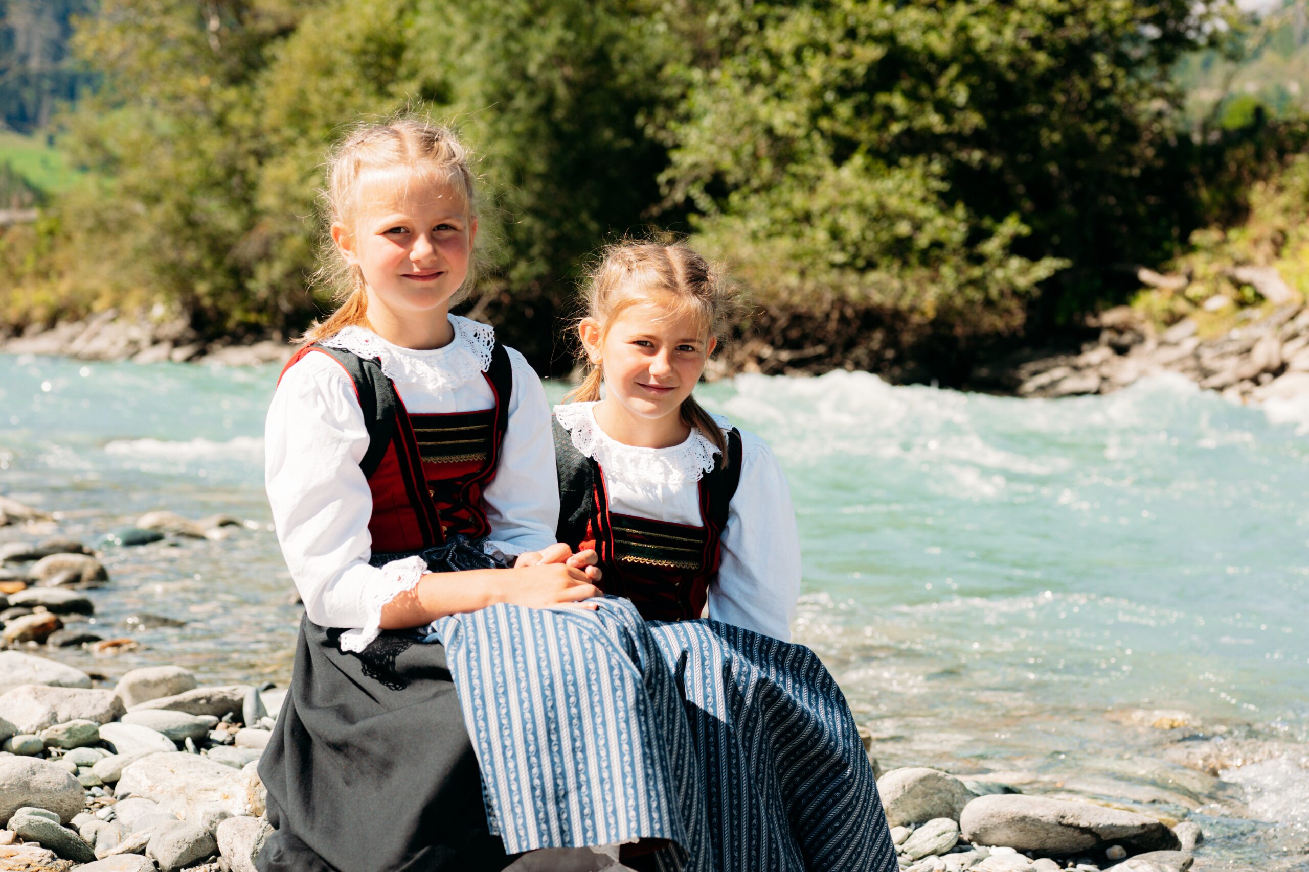 Zwei Mädchen in Virgener Tracht am Ufer des Gletscherflusses Isel.