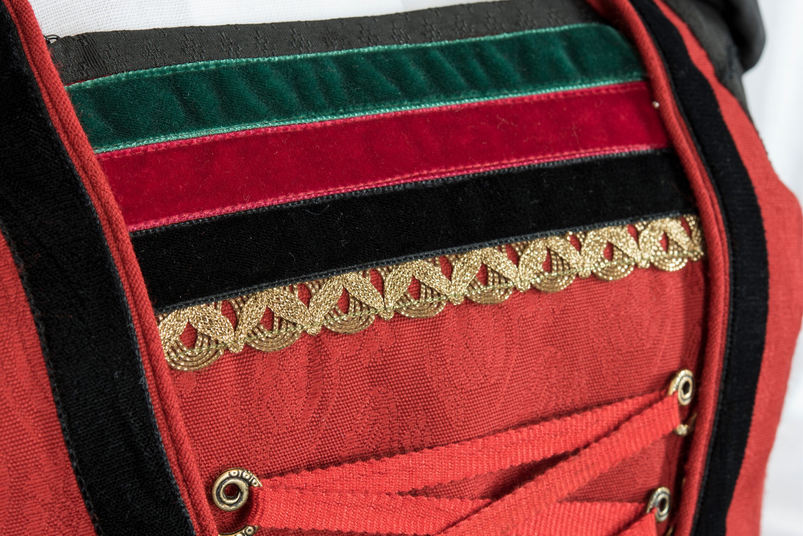 Rotes Mider mit schwarzen und grünen Samtbändern und Goldspitze – typische Details der Iseltaler Tracht. 