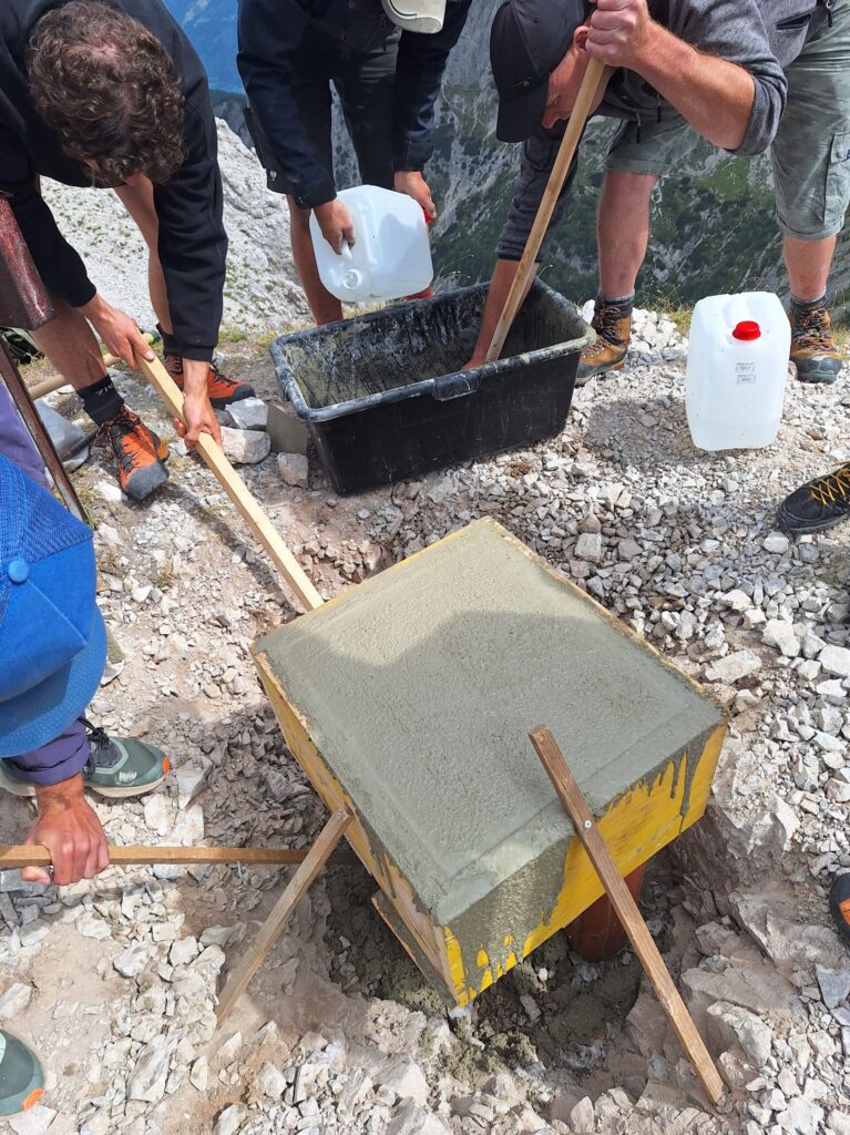 Mehrere Personen gießen ein Beton-Fundament.