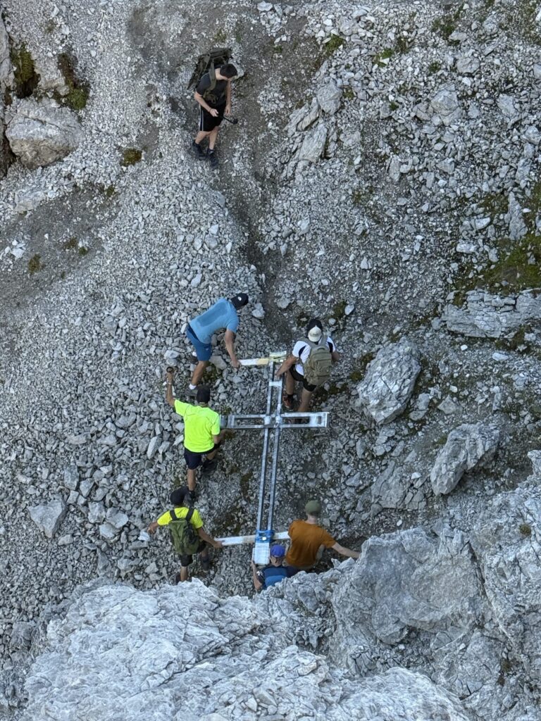Blick von oben auf den Transport des Gipfelkreuzes.