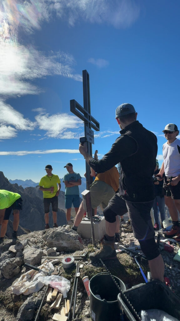Das neue Metallkreuz auf der Gamswiesenspitze wird eingelassen.