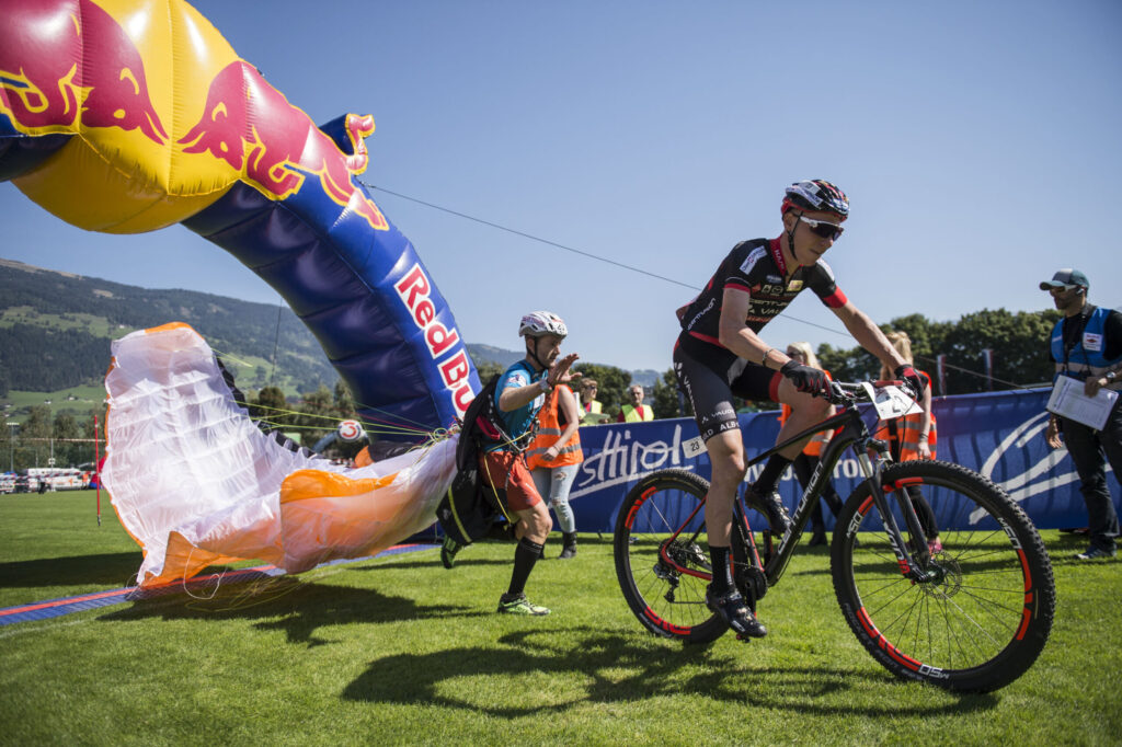 Übergabe von Paragleiter zum Mountainbiker